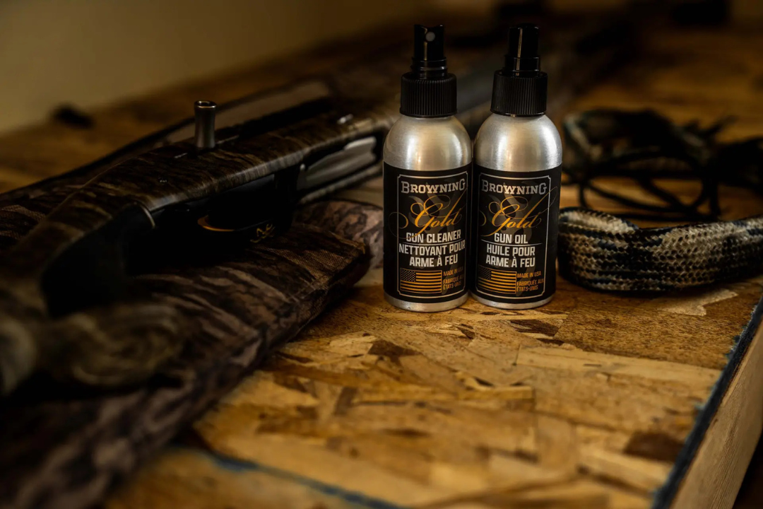 Arme à feu de chasse entourée de produits et outils d'entretien Browning (nettoyant, huile, bore snake)