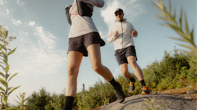 une femme et un homme courent sur un terrain rocheux avec des chaussures de course en sentier